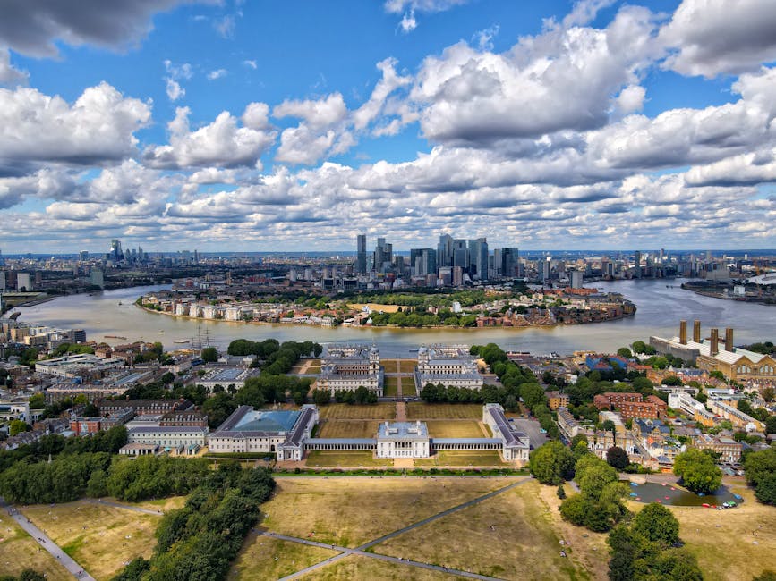 Aerial view of a garden and landscaped park area on a rooftop terrace in Canary Wharf, E14, featuring well-maintained lawns, neatly trimmed hedges, and flower beds with a variety of plants. The terrac